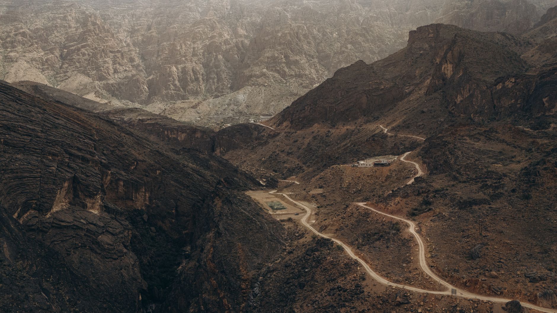 An open Omani road stretching toward distant hills
