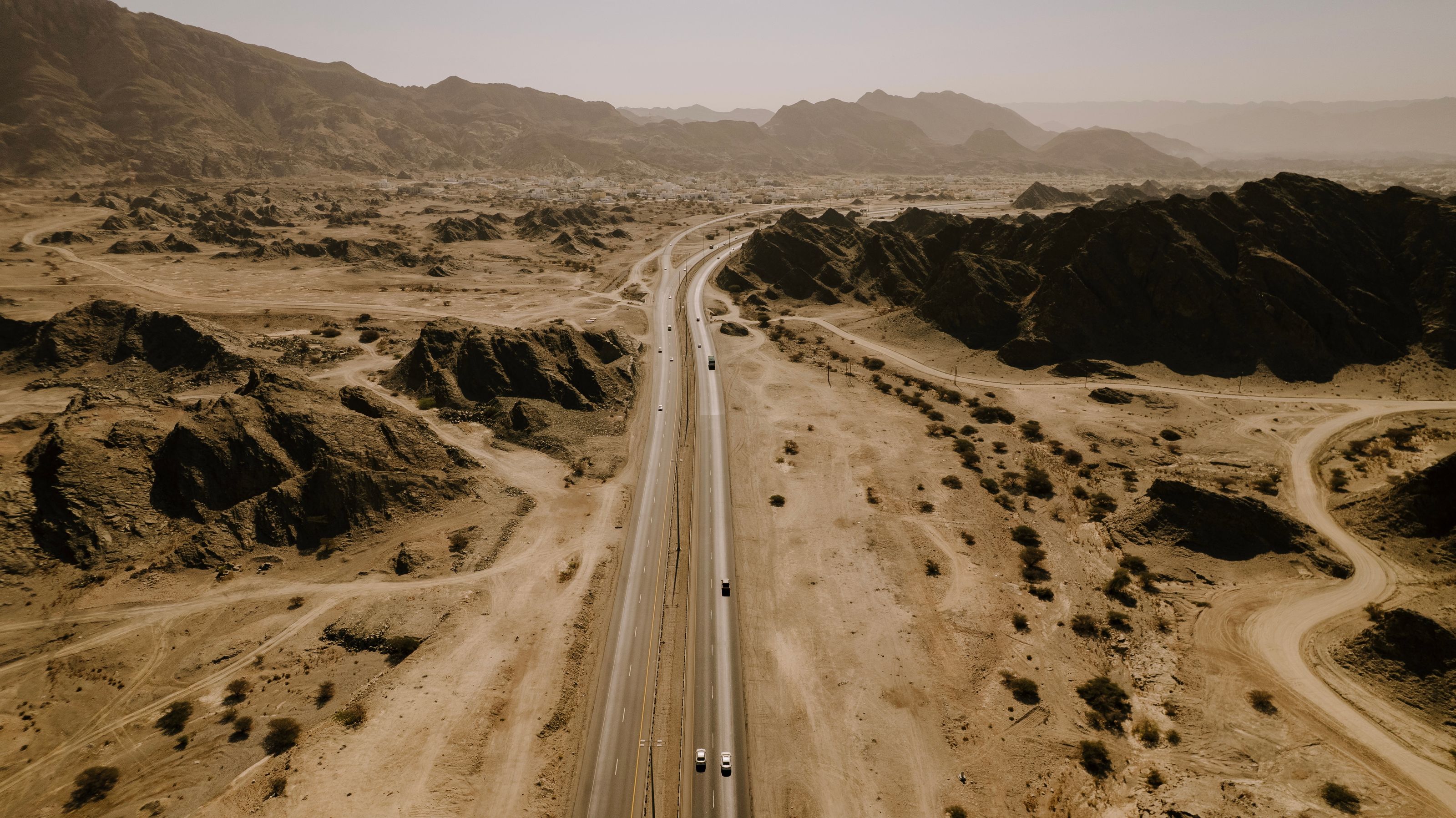 An aerial view of a highway winding through the Oman desert