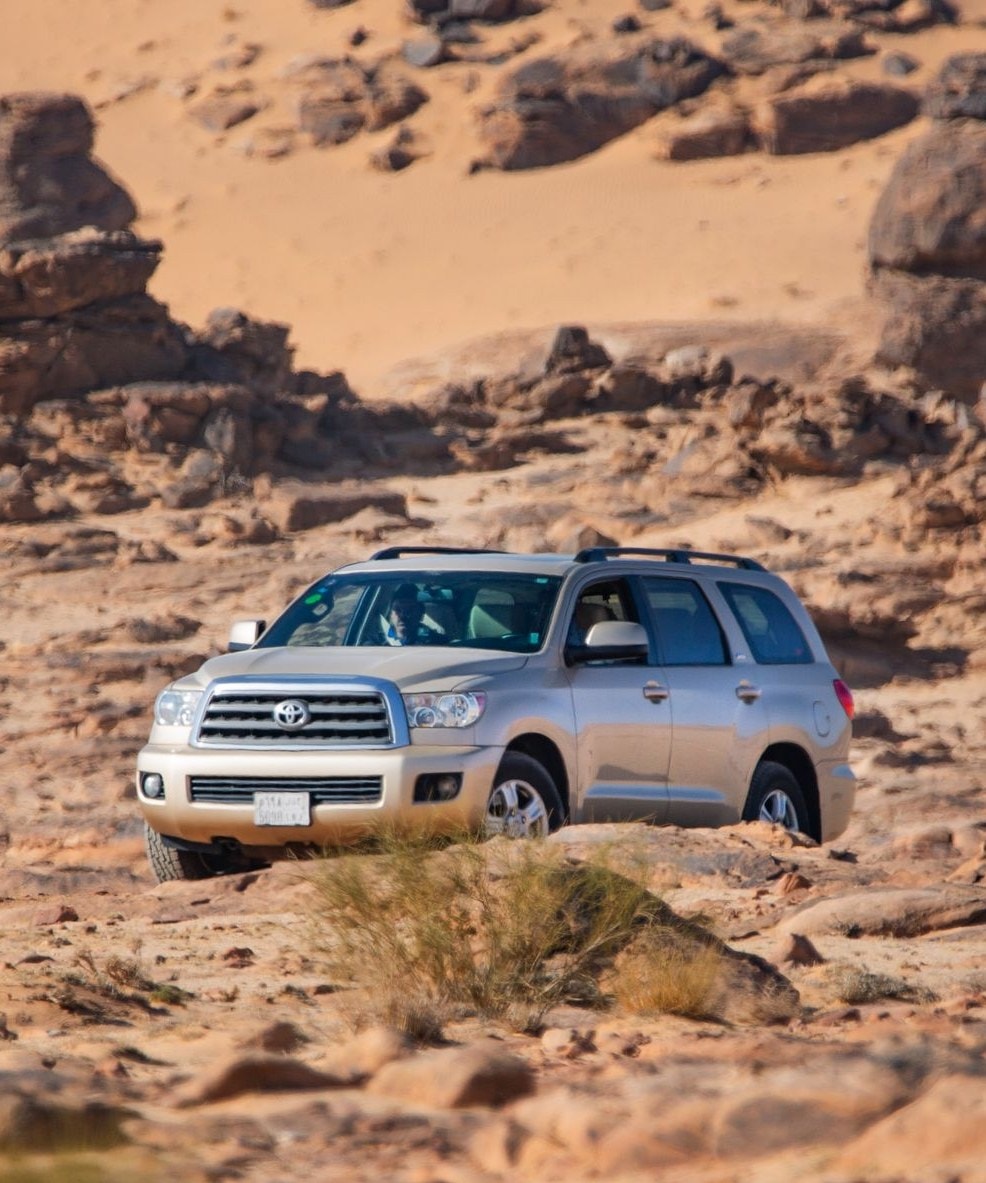 A full-size SUV crossing rocky desert terrain